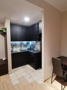a kitchen with black cabinets and a table at ArchiC509 in Tbilisi City