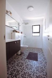 ein Badezimmer mit einem Waschbecken, einem WC und einem Spiegel in der Unterkunft Tavor zimmer אירוח כפרי מול נוף תבור in Daverat
