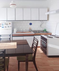 a kitchen with white cabinets and a table and a stove at Dunavska panorama in Golubac