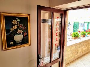 une porte menant à un magasin avec une peinture d'un vase dans l'établissement Villa Palčić, à Novalja
