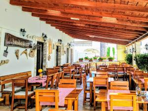 an empty restaurant with wooden tables and chairs at Villa Palčić in Novalja
