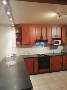 a kitchen with wooden cabinets and a black counter top at A Beach Condo in Durban +21 photos