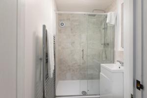 a bathroom with a shower and a toilet and a sink at Skyvillion - STEVENAGE SPACIOUS & COZY 3Bed House with Parking, Wifi, Garden in Aston End