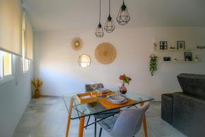 Una sala de estar con una mesa de cristal y un sofá. en Sherryflat Atípika, en Jerez de la Frontera