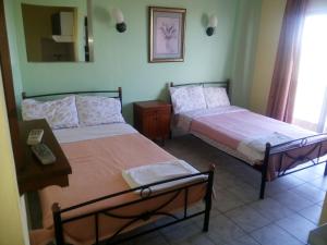 a bedroom with two beds and a phone on a table at Hotel Ifigenia Paralia Katerinis plaz in Paralia Katerinis
