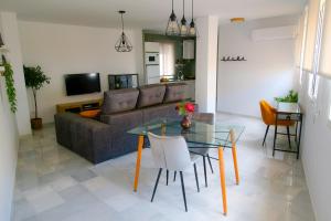 Una sala de estar con una mesa de cristal y un sofá. en Sherryflat Atípika, en Jerez de la Frontera