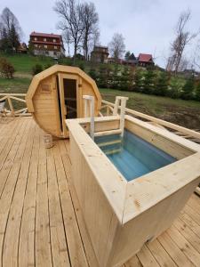 a wooden hot tub on a wooden deck at U Parów - pokoje z jacuzzi i sauna, Białka Tatrzańska in Białka Tatrzańska