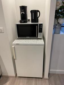 a microwave oven sitting on top of a refrigerator at Chez la p'tite Marie in Savigny-lès-Beaune