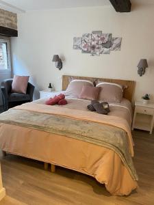 a bedroom with a large bed with two stuffed animals on it at Chez la p'tite Marie in Savigny-lès-Beaune