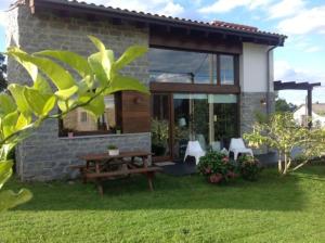 a house with a picnic table in the yard at La Casita de Eva in Colunga