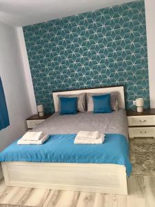 een slaapkamer met een bed met een blauw hoofdeinde bij Lightning Vacation House in Sighişoara