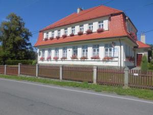 Casa blanca con techo rojo y valla en Penzion Laguna, en Kunratice