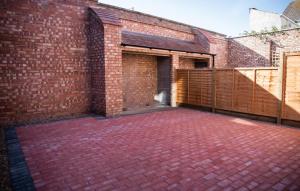 a brick building with two garage doors and a brick patio at Lovely 2-bedroom Seaside Retreat with Free Parking in Great Yarmouth