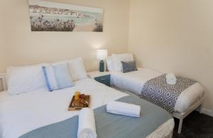 een slaapkamer met 2 bedden en een dienblad met eten bij Lovely 2-bedroom Seaside Retreat with Free Parking in Great Yarmouth
