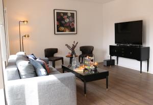 uma sala de estar com um sofá e uma mesa de centro em Wohnung bei Façon em Eckernförde