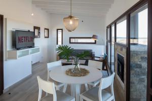 ein Wohnzimmer mit einem Tisch und Stühlen sowie einem TV in der Unterkunft Chocón Medio Suites in Villa El Chocón