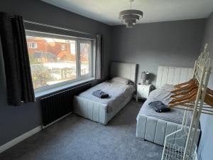 a bedroom with two beds and a window at Viva La Brid in Bridlington