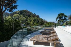une rangée de bancs en bois assis au-dessus d'un bâtiment dans l'établissement Cedros Nature House, à Sintra