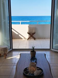 a room with a table and a view of the ocean at Amazing Beachfront Apartment in Hersonissos in Hersonissos