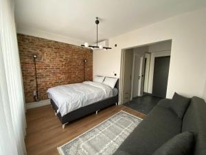 a bedroom with a bed and a couch and a brick wall at Galata VAV Suites in Istanbul