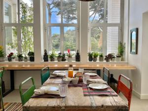 een eettafel met stoelen en een houten tafel met eten bij Cedros Nature House in Sintra