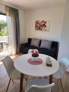 Biały stół i krzesła w salonie w obiekcie Apartmani Josipa w Baskiej Vodzie