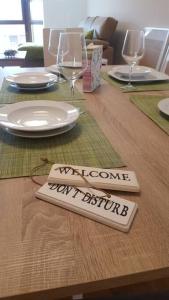 una mesa de madera con una señal navaja de bienvenida. en OKTHEWAY LAXE HOUSE, en Laxe