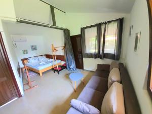 a living room with a couch and a bed at House & Yard Sesil M 110m to beach in Ureki