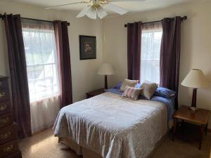 1 dormitorio con 1 cama y 2 ventanas en Large Country Home en Bloomington