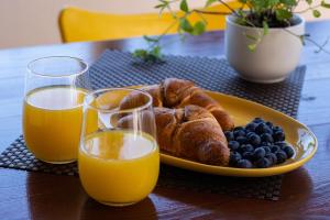 een bord croissants en bosbessen en twee glazen sinaasappelsap bij Apartment Horizon in Split
