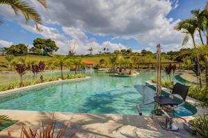 a resort swimming pool with a chair in the foreground at Cyan Resort by Atlantica in Itupeva