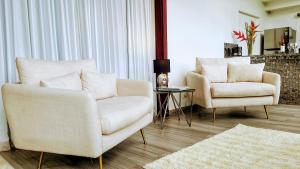 a living room with two chairs and a table at The Residence by Villa Alejandro in Boquete