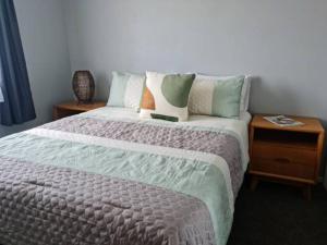 a bedroom with a large bed and two night stands at Gondola Views on Mallard in Rotorua