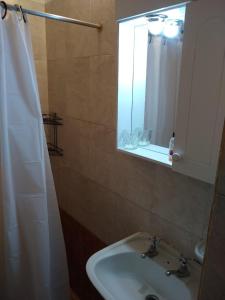 baño con lavabo, espejo y ventana en Departamento Güemes en San Luis
