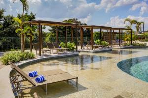 a resort pool with lounge chairs and a pavilion at Cyan Resort by Atlantica in Itupeva