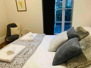 a bedroom with a bed with pillows and a window at Luxury Fulham Flat with 5* touches nr River Thames in London