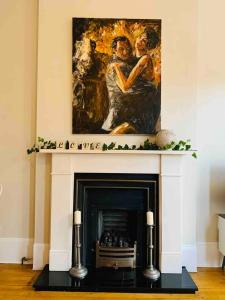 a painting above a fireplace in a living room at Luxury Fulham Flat with 5* touches nr River Thames in London