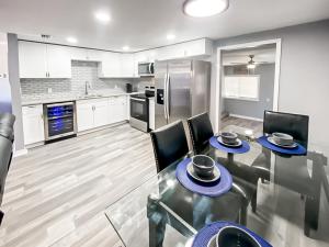 a kitchen with a table and chairs and a kitchen with a refrigerator at Sarasota Modern, Spacious, Comfy, Queen Beds, Backyard Rental in Sarasota