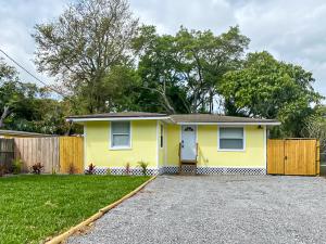 una casa amarilla con una valla en un patio en Sarasota Modern, Spacious, Comfy, Queen Beds, Backyard Rental, en Sarasota