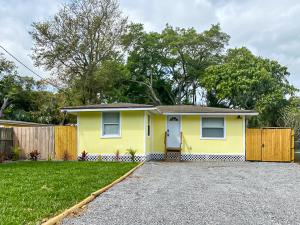 a yellow house with a fence in a yard at Sarasota Modern, Spacious, Comfy, Queen Beds, Backyard Rental in Sarasota