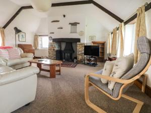 a living room with a couch and a fireplace at Trevenning Barn in Bodmin