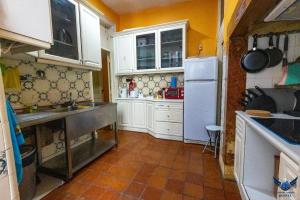 una piccola cucina con armadietti bianchi e pavimento piastrellato di Lisbon Angels Hostel a Lisbona