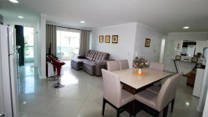 sala de estar con mesa y sofá en 1020 - Apto 03 dormitórios para locação em Bombinhas - Residencial Alameda Verde Apto 201, en Bombinhas