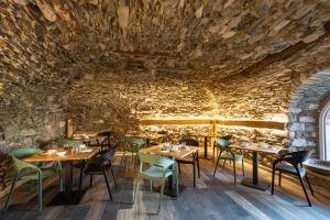 un restaurante con mesas y sillas en una pared de piedra en Agriturismo Il Medeghino, en Musso