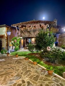 una casa con un patio de piedra por la noche en Apartamentos Rurales L'Arquera en Llanes