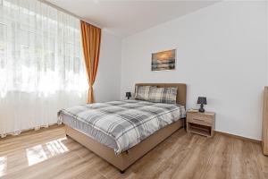 a white bedroom with a bed and a window at Villa Ana Bački Petrovac in Bački Petrovac