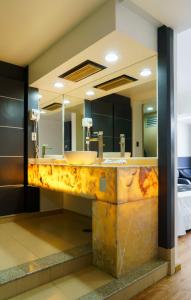 Un baño con un lavabo oxidado y espejos. en Hotel Ibiza Plaza, en Ciudad de México