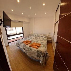 1 dormitorio con 1 cama con 2 toallas en Edificio el tulipán en Santa Teresita