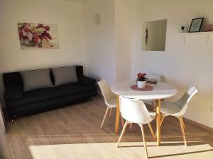 a living room with a table and chairs and a couch at Apartmani Josipa in Baška Voda