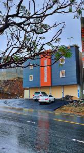a building with two cars parked in a parking lot at ليلك lilac in Abha
